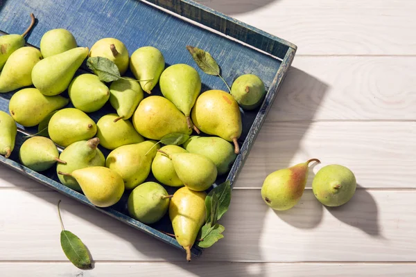 Fresh organic pears in crate on wooden table — Stock Photo, Image