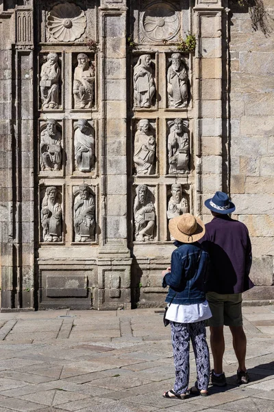 Turistas mirando antiguas esculturas de Puerta Santa de la Catedral de Santiago de Compostela — Foto de Stock