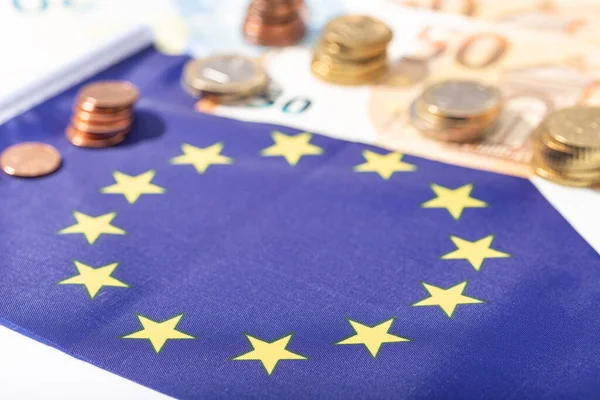 Avrupa Birliği 'nin Coronavirus Covid-19 pandemik konsepti için finansal uyarısı. Avro banknotları ve sikkeleriyle Avrupa Birliği bayrağı