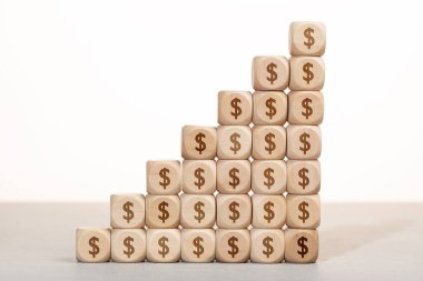 Büyüme, zenginlik ya da zenginlik kavramı. Dolar sembolüyle istiflenmiş bir grup tahta blok.