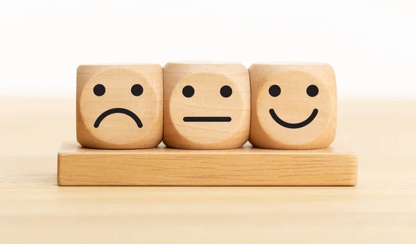 User service feedback, rating and customer review, experience, satisfaction survey concept. Wooden blocks with facial expressions