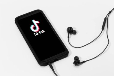 Galiçya, İspanya; 25 Mart 2020: Kulaklıklar ve Tik Tok logosu olan akıllı telefon ekranı