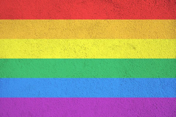 Rainbow flag painted on wall. Grunge background textured. Gay pride flag LGBTQ
