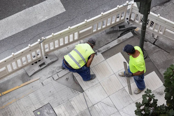 Construction workers repairing a sidewalk. Maintenance concept