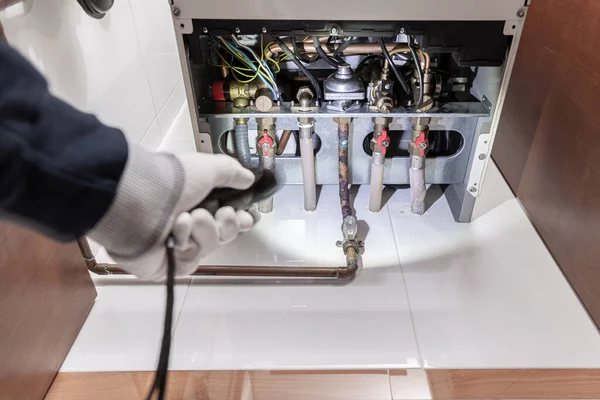 Technician inspecting a gas heater or heating boiler in a house. Maintenance concept