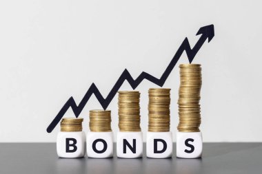 Küp bloklardaki BONDS mesajının tepesinde artan grafik oku olan bozuk paralar yığını. Boşluğu kopyala