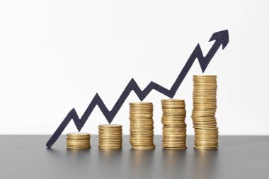 Para yığınları ve gri arka plandaki yükselen ok pozitif finansal büyüme, iş başarısı kavramını gösteriyor. Boşluğu kopyala