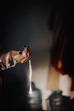 Siyah arkaplanda izole edilmiş kurdeleli eller ışıkla vurgulandı