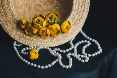 yeşil yaprak ile sarı nilüfer çiçek buketi. taze sökük. Bir hasır şapka. kumaş siyah arka plan üzerine kapatın. Sarı nilüfer. ufuk bitki, kırmızı veri kitap. çiçek kompozisyon düz yatıyordu