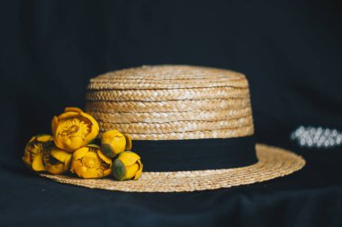 yeşil yaprak ile sarı nilüfer çiçek buketi. taze sökük. Bir hasır şapka. kumaş siyah arka plan üzerine kapatın. Sarı nilüfer. ufuk bitki, kırmızı veri kitap. çiçek kompozisyon düz yatıyordu