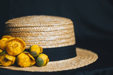 yeşil yaprak ile sarı nilüfer çiçek buketi. taze sökük. Bir hasır şapka. kumaş siyah arka plan üzerine kapatın. Sarı nilüfer. ufuk bitki, kırmızı veri kitap. çiçek kompozisyon düz yatıyordu