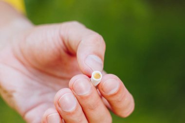 Sigara doğa yeşil ağaçlar arka planı üzerinde bir sakallı bir adam elinde sönmüş. Nikotin filtre. Sağlıksız yaşam tarzı. Yakın çekim. sigara izmariti. Macrophoto