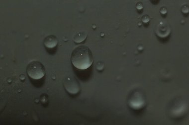 Gri tonlu arka planda su damlaları yakın. Plastik PVC yüzey veya grunge kabarcıkları ile soyut beyaz gri ıslak doku. Gerçekçi saf su damlacıkları yoğunlaştırılmış. Tuval deri doku detay