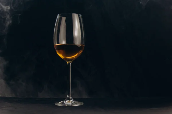 Siyah bir arka planda bir bardak beyaz şarap. nargile duman cam sarar. dinlenme, tatil. alkollü içecek çekim. beyaz sis — Stok fotoğraf