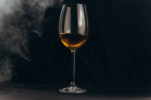 Siyah bir arka planda bir bardak beyaz şarap. nargile duman cam sarar. dinlenme, tatil. alkollü içecek çekim. beyaz sis — Stok fotoğraf