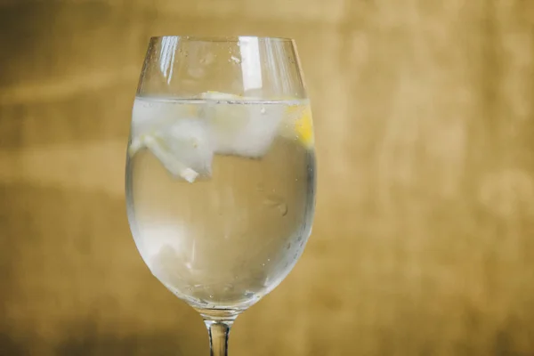 Un verre de limonade maison avec de la glace et de la chaux sur un fond brun rustique en bois. repos, vacances, fête. cristal verre gros plan. espace de copie — Photo