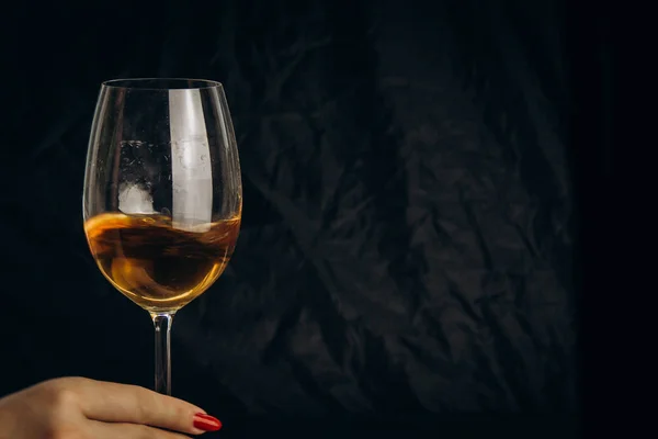 Siyah bir arka planda beyaz şarap bir bardak tutan kadın el kırpılmış. dinlenme, tatil, parti. Alkollü içmek izole içmek. — Stok fotoğraf