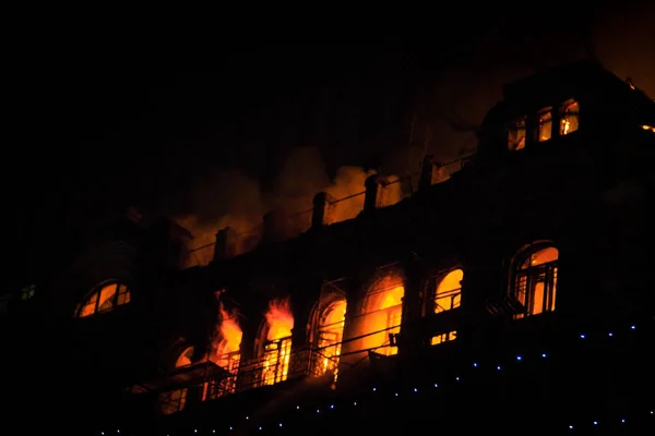 Feuer in den Fenstern des Altbaus in der Nacht im Winter vor dem Hintergrund von Girlanden. Löscharbeiten. kiev, 20. Januar 2018 — Stockfoto