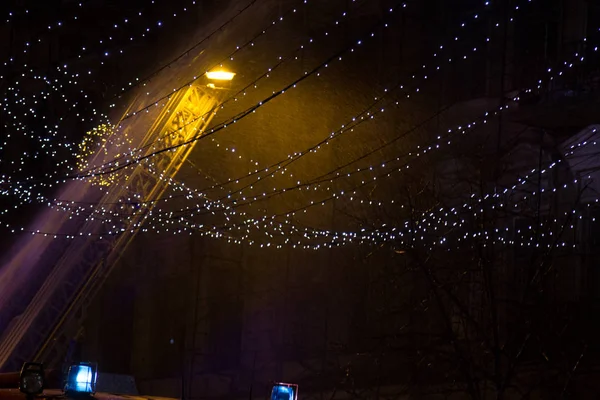 Пожар в окнах старого здания ночью зимой на фоне гирлянд. Огонь гаснет. Киев, Январь 20, 2018 — стоковое фото