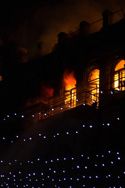 Feuer in den Fenstern des Altbaus in der Nacht im Winter vor dem Hintergrund von Girlanden. Löscharbeiten. kiev, 20. Januar 2018 — Stockfoto