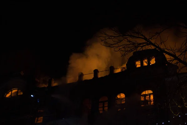 Feuer in den Fenstern des Altbaus in der Nacht im Winter vor dem Hintergrund von Girlanden. Löscharbeiten. kiev, 20. Januar 2018 — Stockfoto