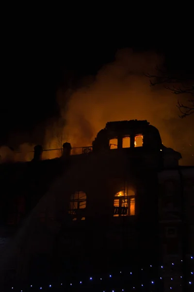 Fogo nas janelas do antigo edifício à noite no inverno contra o fundo de guirlandas. extinção de incêndios. Kiev, 20 de janeiro de 2018 — Fotografia de Stock