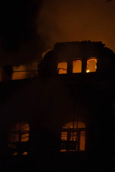 Vuur in de ramen van het oude gebouw 's nachts in de winter tegen de achtergrond van slingers. brand blussen. Kiev, 20 januari 2018 — Stockfoto