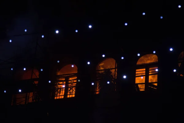 Φωτιά στα παράθυρα του παλιού κτηρίου τη νύχτα το χειμώνα με φόντο γιρλάντες. πυροσβεστικών πυρκαγιών. Κίεβο, 20 Ιανουαρίου, 2018 — Φωτογραφία Αρχείου
