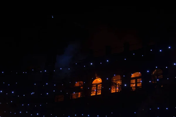 Feuer in den Fenstern des Altbaus in der Nacht im Winter vor dem Hintergrund von Girlanden. Löscharbeiten. kiev, 20. Januar 2018 — Stockfoto