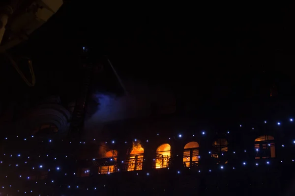 Пожежа в вікнах старої будівлі вночі взимку на тлі гірлянд. пожежогасіння. Києві, 20 січня 2018 — стокове фото