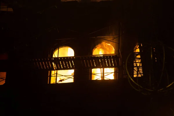 Fogo nas janelas do antigo edifício à noite no inverno contra o fundo de guirlandas. extinção de incêndios. Kiev, 20 de janeiro de 2018 — Fotografia de Stock