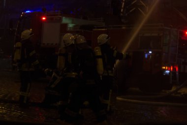 İtfaiyeciler iş başında. kış gecesi yangın suyu söndürme. Yangın kulesi, yangın hortumu. Kiev 20 Ocak 2018