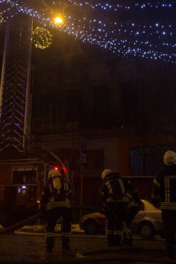 İtfaiyeciler iş başında. kış gecesi yangın suyu söndürme. Yangın kulesi, yangın hortumu. Kiev, 20 Ocak 2018