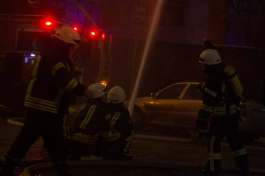 İtfaiyeciler iş başında. kış gecesi yangın suyu söndürme. Yangın kulesi, yangın hortumu. Kiev, 20 Ocak 2018