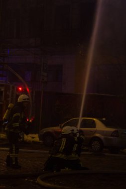 İtfaiyeciler iş başında. kış gecesi yangın suyu söndürme. Yangın kulesi, yangın hortumu. Kiev, 20 Ocak 2018