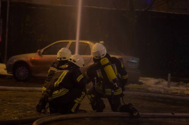 İtfaiyeciler iş başında. kış gecesi yangın suyu söndürme. Yangın kulesi, yangın hortumu. Kiev, 20 Ocak 2018