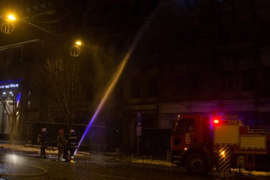 İtfaiyeciler iş başında. kış gecesi yangın suyu söndürme. Yangın kulesi, yangın hortumu. Kiev, 20 Ocak 2018