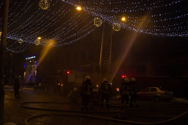 Bomberos en el trabajo. extinguiendo el agua de fuego en la noche de invierno. torre de bomberos, manguera de incendios. Kiev enero 20, 2018 —  Fotos de Stock