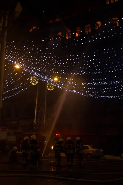 Petugas pemadam kebakaran di tempat kerja. memadamkan air api di malam musim dingin. menara pemadam kebakaran, selang kebakaran. Kiev 20 Januari 2018 — Stok Foto