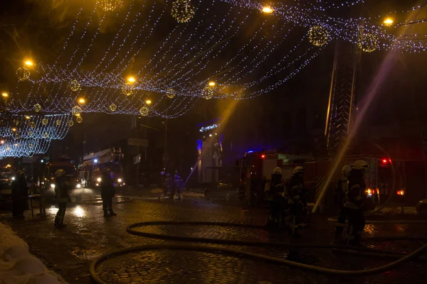 Bomberos en el trabajo. extinguiendo el agua de fuego en la noche de invierno. torre de bomberos, manguera de incendios. Kiev enero 20, 2018 —  Fotos de Stock