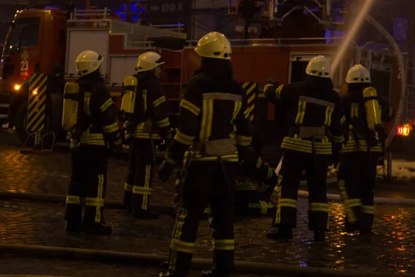 Bomberos en el trabajo. extinguiendo el agua de fuego en la noche de invierno. torre de bomberos, manguera de incendios. Kiev enero 20, 2018 —  Fotos de Stock