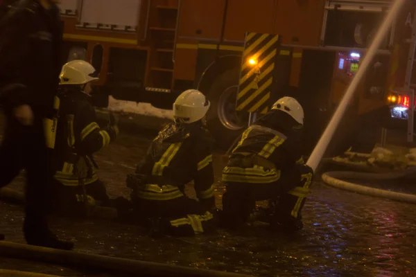 Vigili del fuoco al lavoro. spegnere l'acqua del fuoco nella notte d'inverno. Torre antincendio, manichetta antincendio. Kiev, 20 gennaio 2018 — Foto Stock