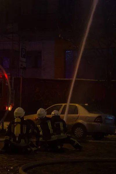 Vigili del fuoco al lavoro. spegnere l'acqua del fuoco nella notte d'inverno. Torre antincendio, manichetta antincendio. Kiev, 20 gennaio 2018 — Foto Stock