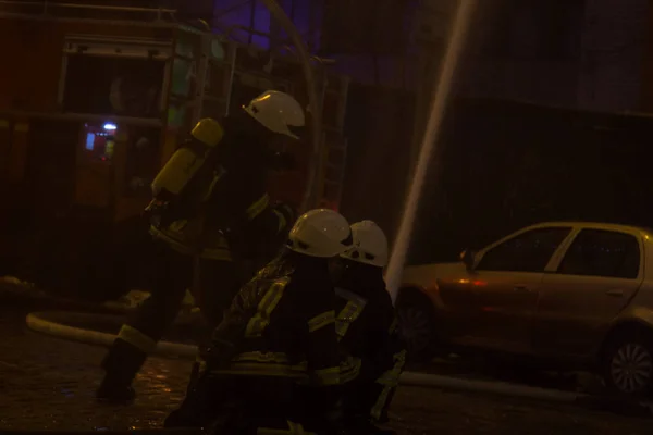 Hasiči v práci. v zimní noci hasící vodu. požární věž, požární hadice. Kyjev, 20. ledna 2018 — Stock fotografie