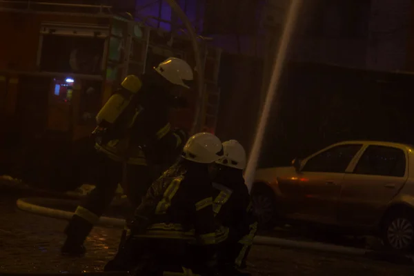 Bomberos en el trabajo. extinguiendo el agua de fuego en la noche de invierno. torre de bomberos, manguera de incendios. Kiev, 20 de enero de 2018 —  Fotos de Stock