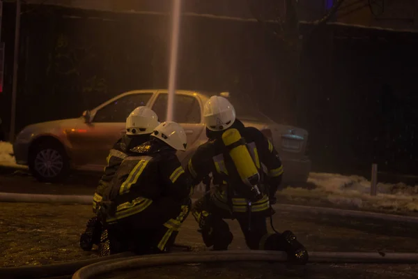 Bombeiros a trabalhar. extinguindo a água de fogo na noite de inverno. Torre de incêndio, mangueira de incêndio. Kiev, 20 de janeiro de 2018 — Fotografia de Stock