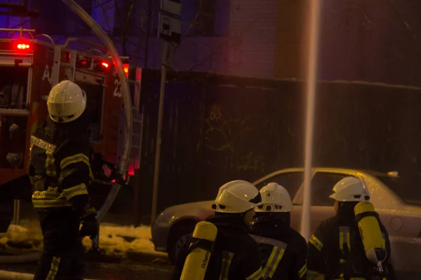 Bombeiros a trabalhar. extinguindo a água de fogo na noite de inverno. Torre de incêndio, mangueira de incêndio. Kiev, 20 de janeiro de 2018 — Fotografia de Stock