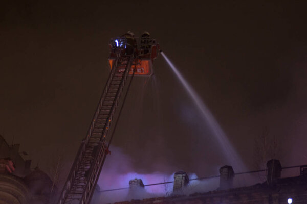 firefighters at work. extinguishing fire water in the winter night. fire tower, fire hose. Kiev, January 20, 2018