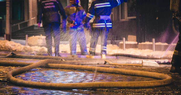 Bomberos en el trabajo. extinguiendo el agua de fuego en la noche de invierno. torre de bomberos, manguera de incendios. Kiev, 20 de enero de 2018 —  Fotos de Stock