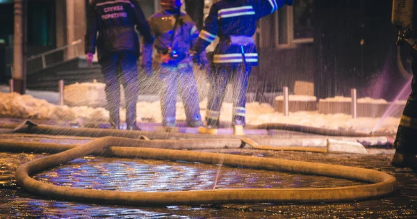 Bomberos en el trabajo. extinguiendo el agua de fuego en la noche de invierno. torre de bomberos, manguera de incendios. Kiev, 20 de enero de 2018 — Foto de Stock